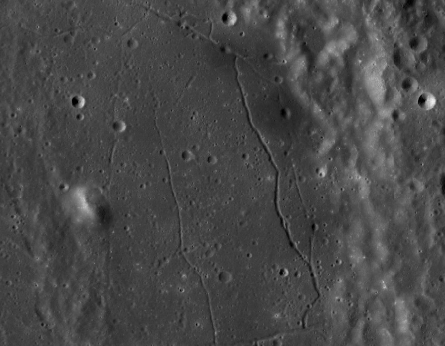 Fragment krateru Alfons. Widoczny kanał lawowy przebiegający pod kraterami wokół których regolit jest nietypowo ciemniejszy.